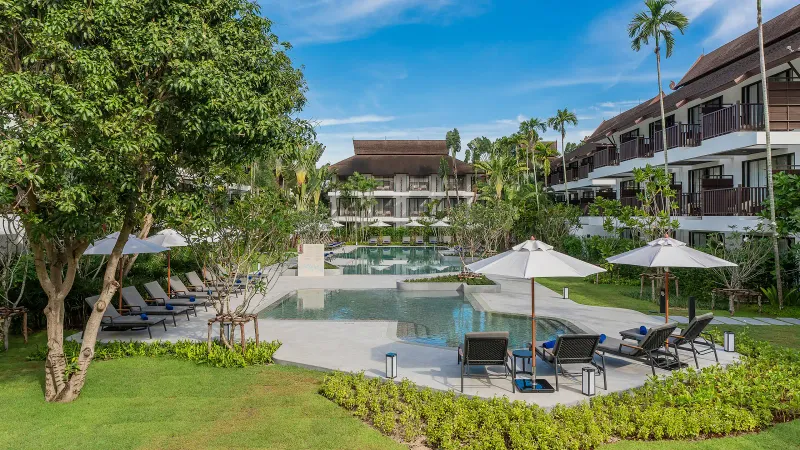 La piscina dell'Amari Koh Samui con lettini e ombrelloni sotto le ali di legno in stile thailandese delle camere a Chaweng