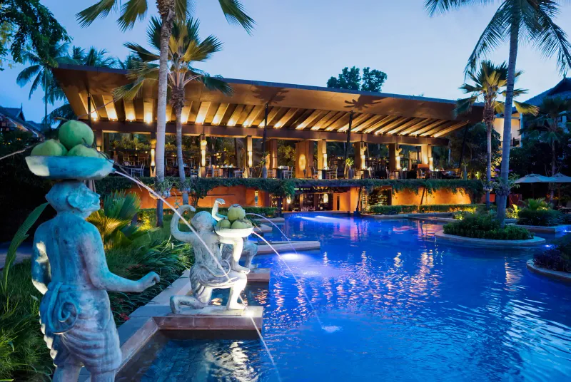 夕暮れの、噴水の像がある、照明されたプールテラスと開放的なレストラン。Anantara Bophut Koh Samui