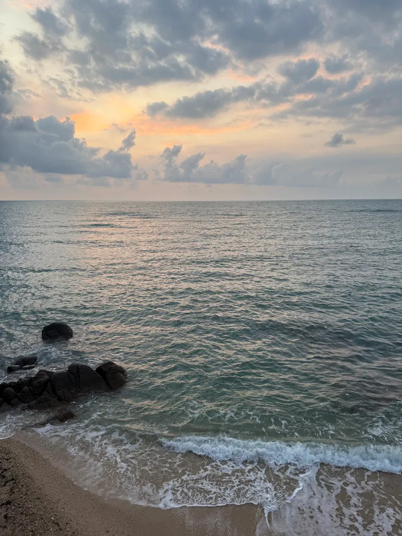 Sunset over a rocky cove on Chaweng Beach's quiet northern stretch, Koh Samui