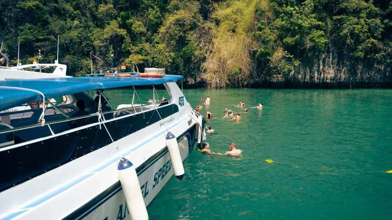 Family swimming break during a calm-water Gulf of Thailand boat day