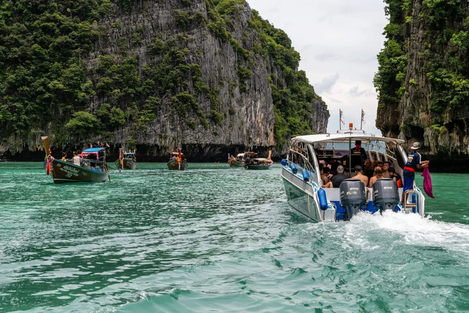 Speedboat passing limestone island scenery on a Gulf of Thailand day trip