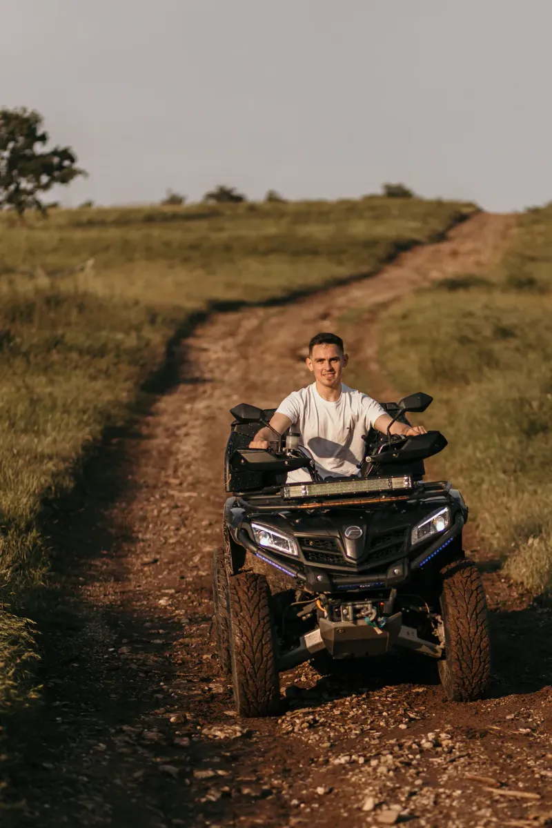 A rider on a quad bike along a scenic countryside trail in Thailand