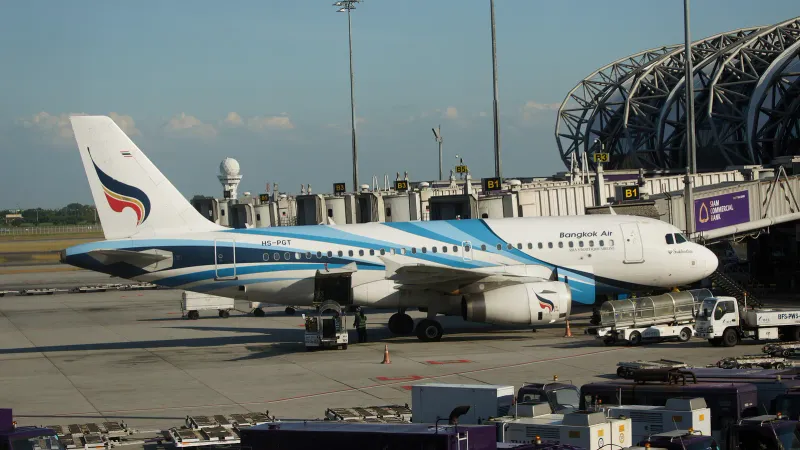 Airbus A319 de Bangkok Airways à une porte de l'aéroport de Suvarnabhumi, entouré de véhicules de piste