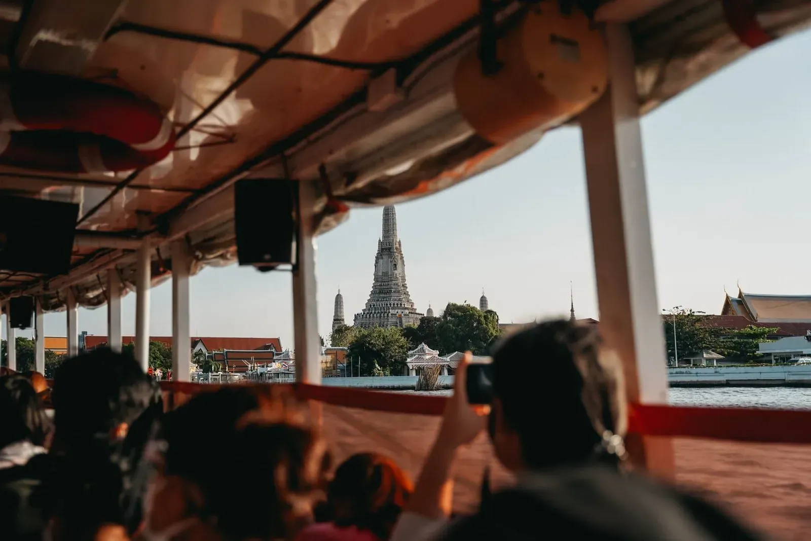 Riverboat passengers viewing Wat Arun temple on the Chao Phraya River in Bangkok, the starting point of this Thailand itinerary