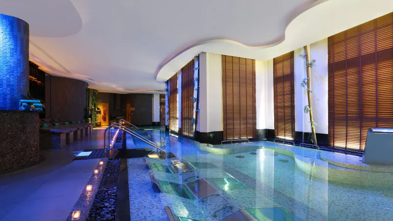 Vasca idroterapica della spa del Banyan Tree Samui con lettini sommersi, bambù e luci calde