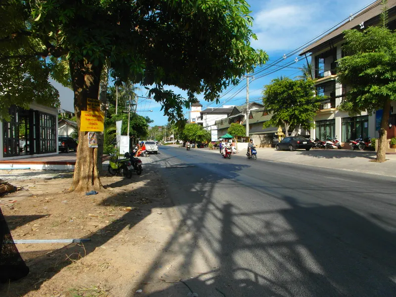 Quiet village lane with shops and a hotel building along the coastal road near Banyan Tree Samui, Lamai, Koh Samui