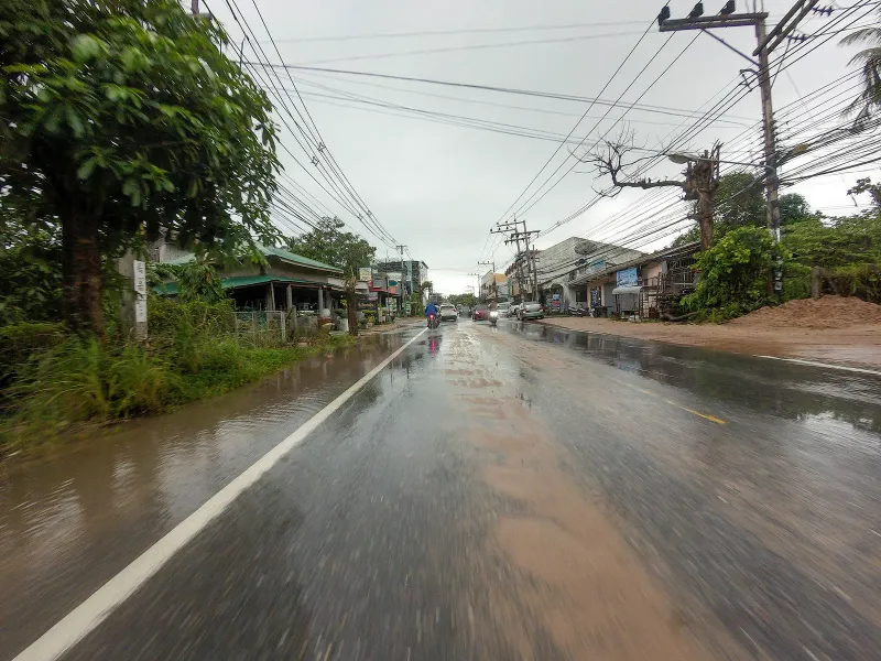 Rain-slicked coastal road with palm trees near Banyan Tree Samui, south Koh Samui