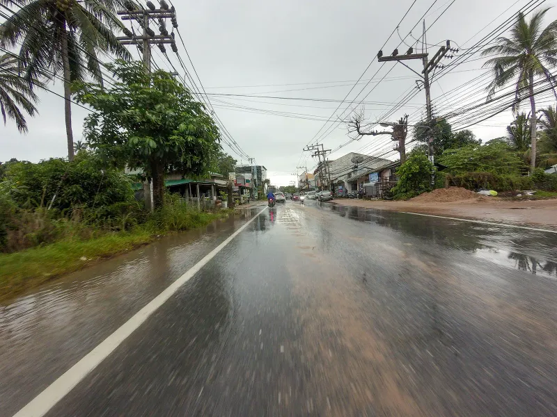 Traffic on the wet coast road through Maret village close to Banyan Tree Samui, Koh Samui