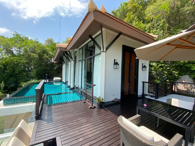 Villa sulla collina del Banyan Tree Samui con un deck di legno, una piscina privata piastrellata e la foresta dietro