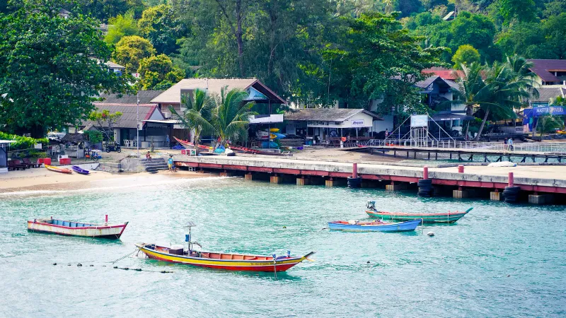 The pier at Bophut with longtail boats moored in the shallows, Koh Samui