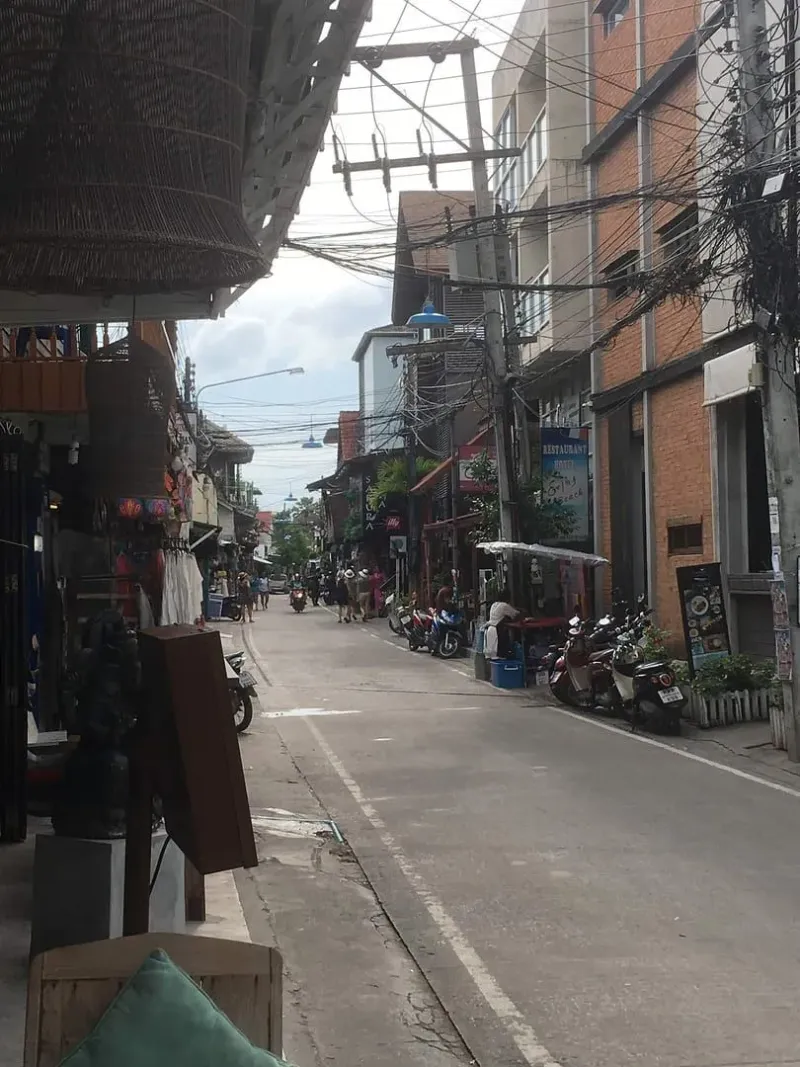 Side street in Bophut's Fisherman's Village, Koh Samui, with shops and parked scooters