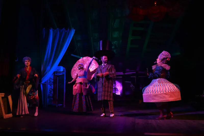 Vibrant costumes and dramatic lighting in a theatrical stage performance