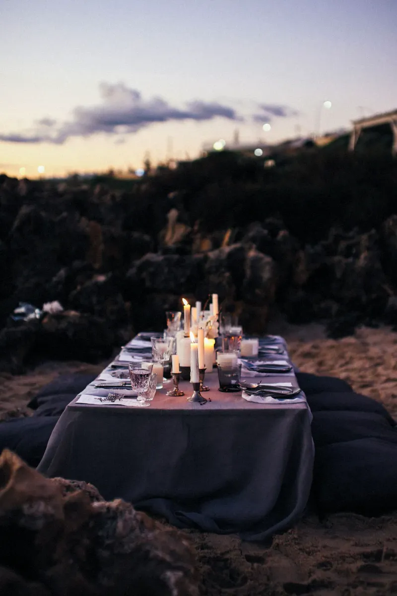 Candlelit dinner table set outdoors at night