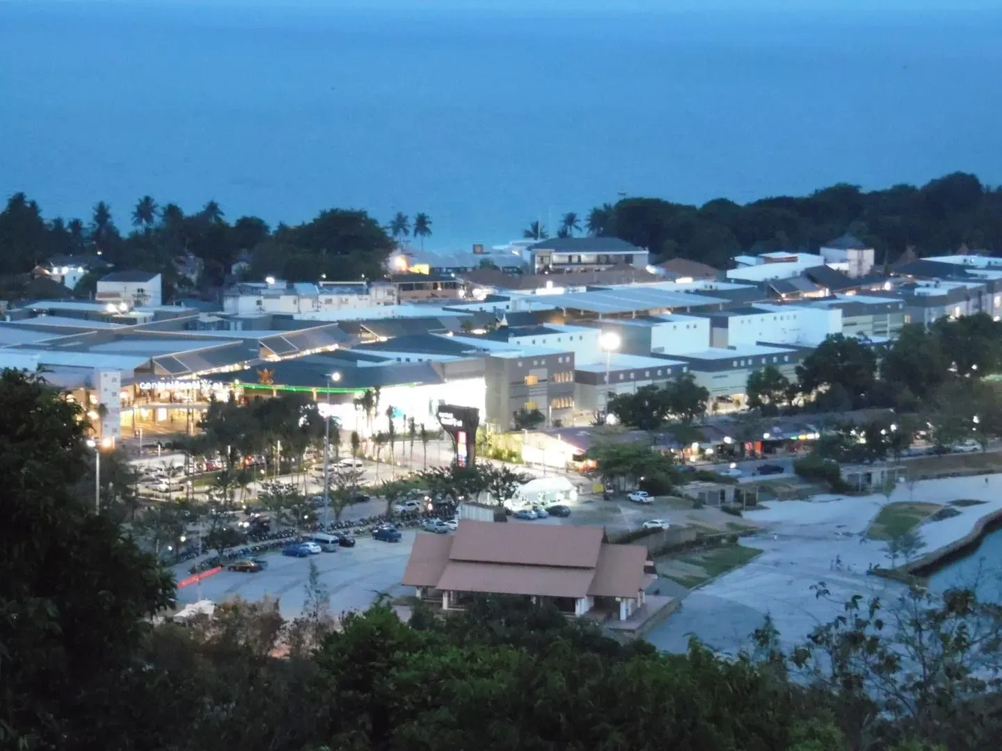 Aerial night view of Central Samui shopping mall complex lit up near the coast in Chaweng, Koh Samui