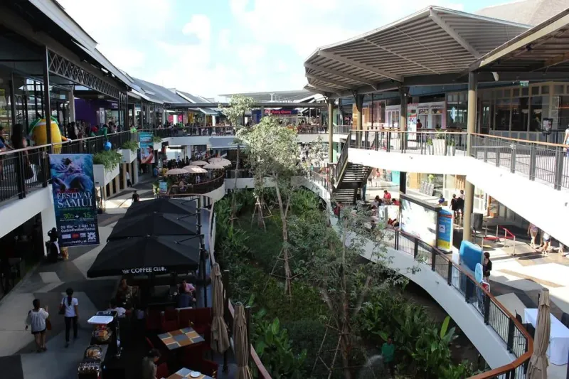エスカレーター、テラス席、緑豊かな植栽のある、Central Samuiの中庭の内部