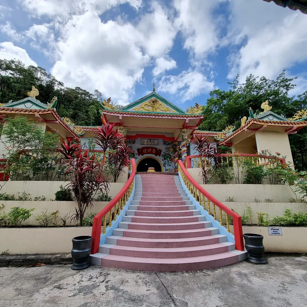 Rosafarbene Steintreppe, die zum rot-goldenen Eingang des Guam Im Schreins hinaufführt