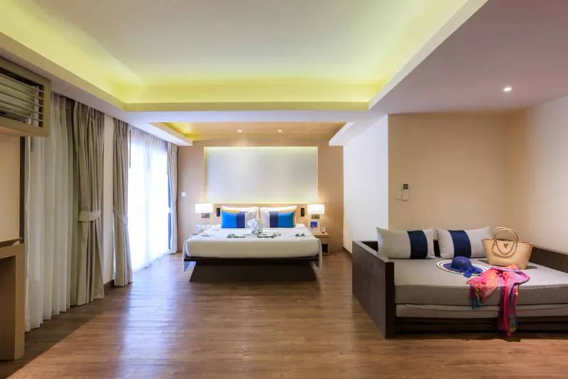 Chambre Grand Premier du Chaweng Regent Beach Resort avec parquet, lit king-size et canapé