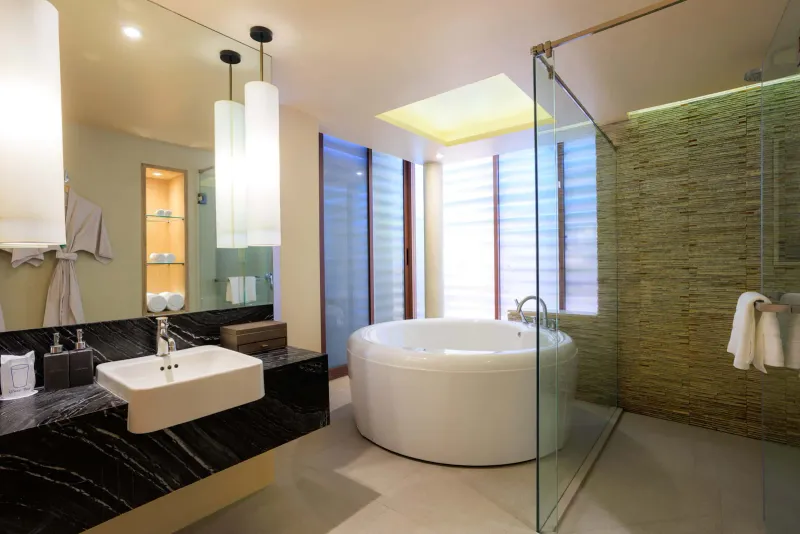 Salle de bains d'une chambre avec vasque en marbre, baignoire ronde et douche en verre au Chaweng Regent Beach Resort
