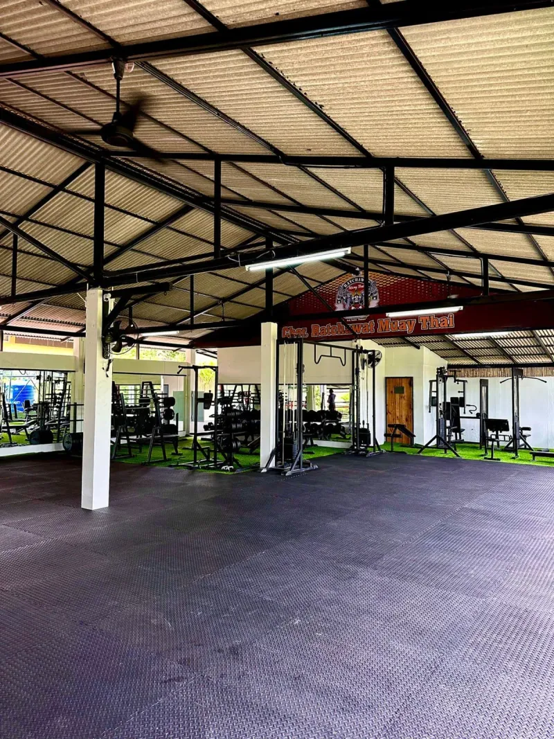 The covered Plai Laem training hall with gym equipment and a mat floor