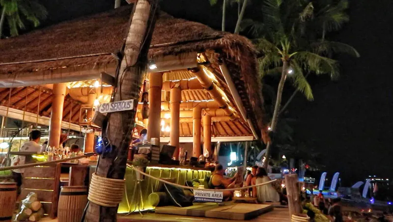 The thatched-roof bamboo bar interior at Coco Tam's lit up at night, Bophut Beach