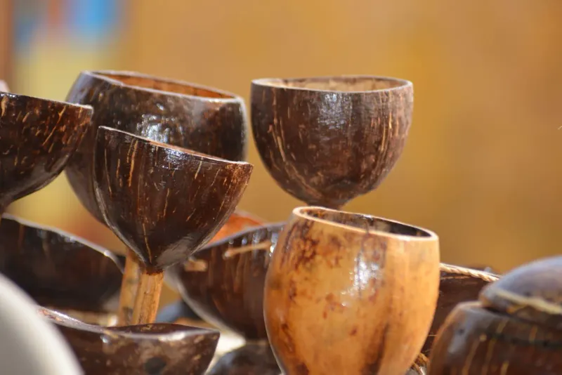 Handcrafted coconut shell bowls displayed for sale at an outdoor market stall