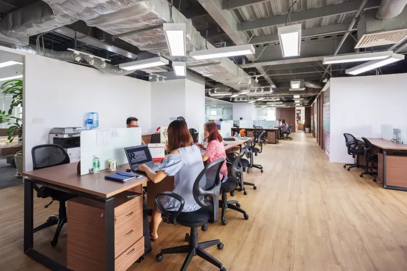 Spacious coworking office with people collaborating at desks, similar layout to Samui coworking spaces
