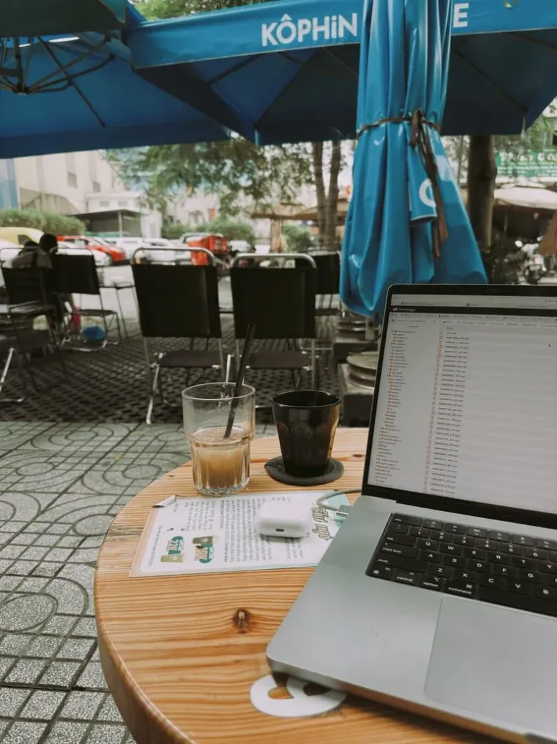 Laptop and coffee at an outdoor café table, typical of Koh Samui's remote work spots