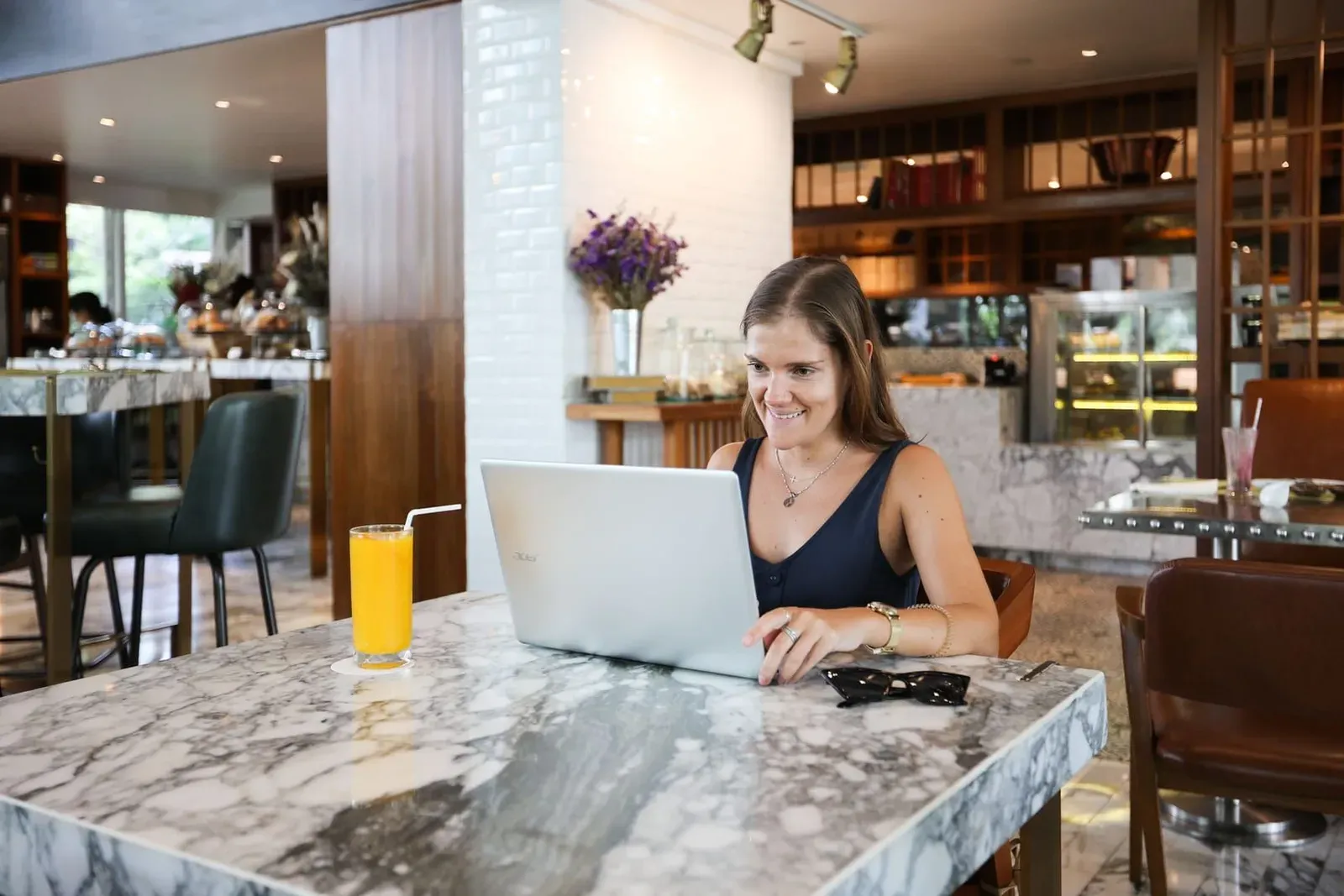 Remote worker at a laptop in a modern café interior similar to Koh Samui's coworking-adjacent café scene