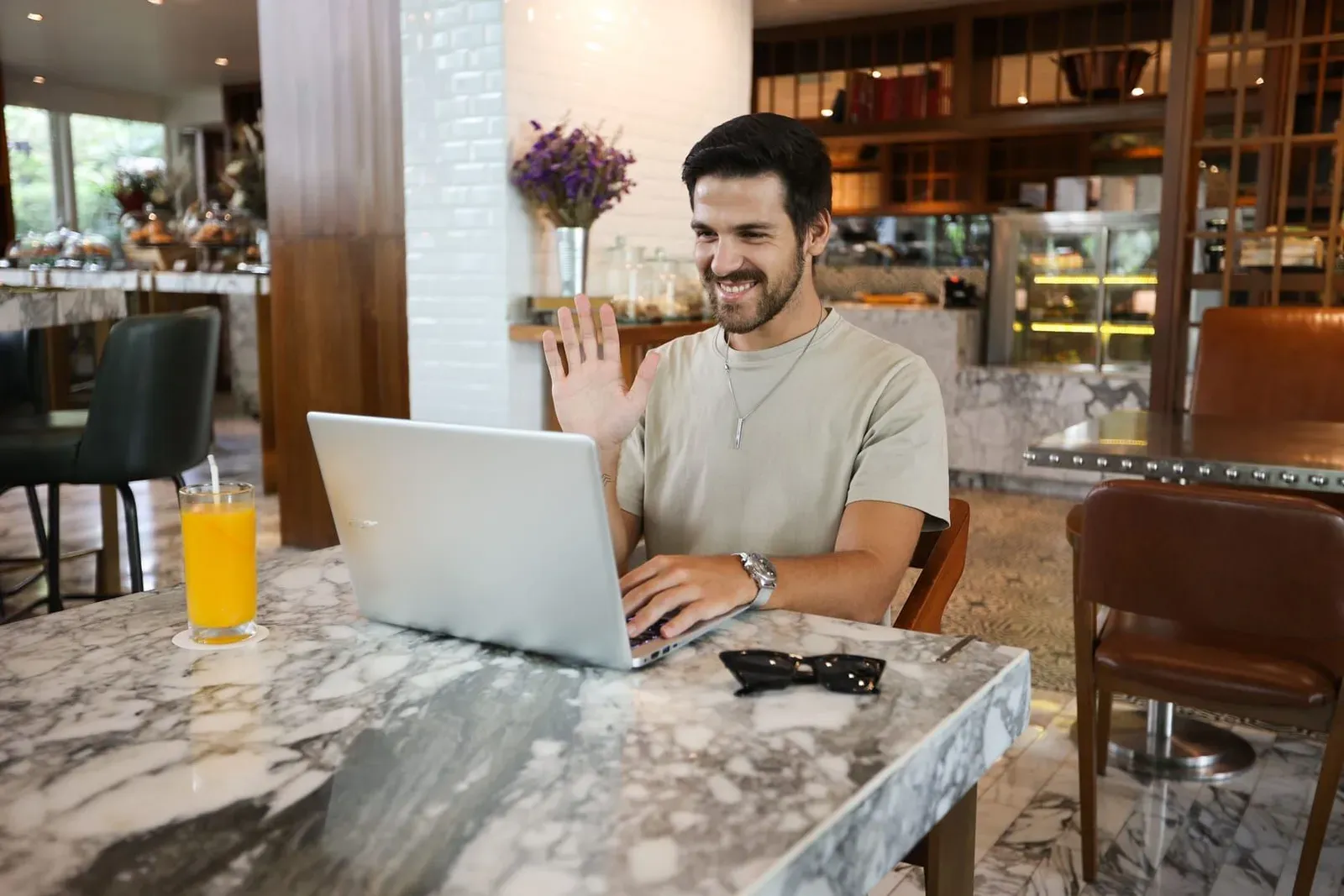 Person on a video call from a laptop at a café table, representing remote client calls on Koh Samui's wifi and mobile networks