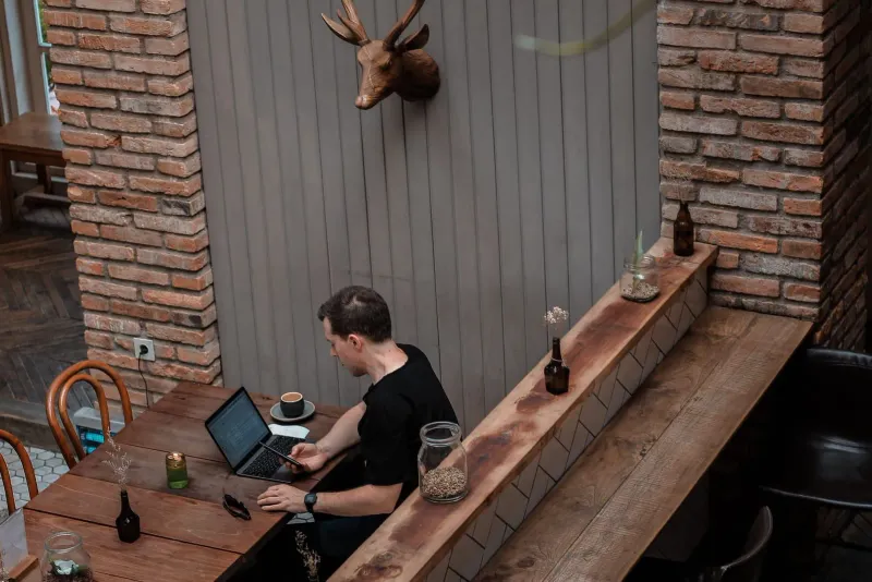 Digital nomad working from a rustic café setting similar to Koh Samui's coworking cafés
