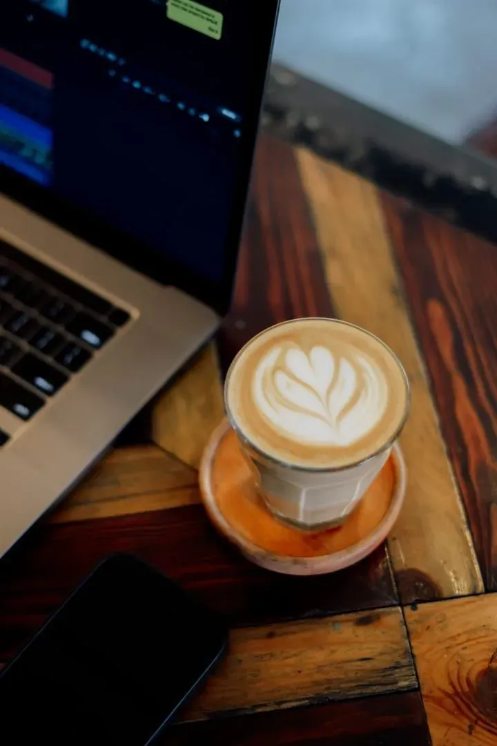 Coffee beside a laptop at a café desk, representative of coworking cafés on Koh Samui