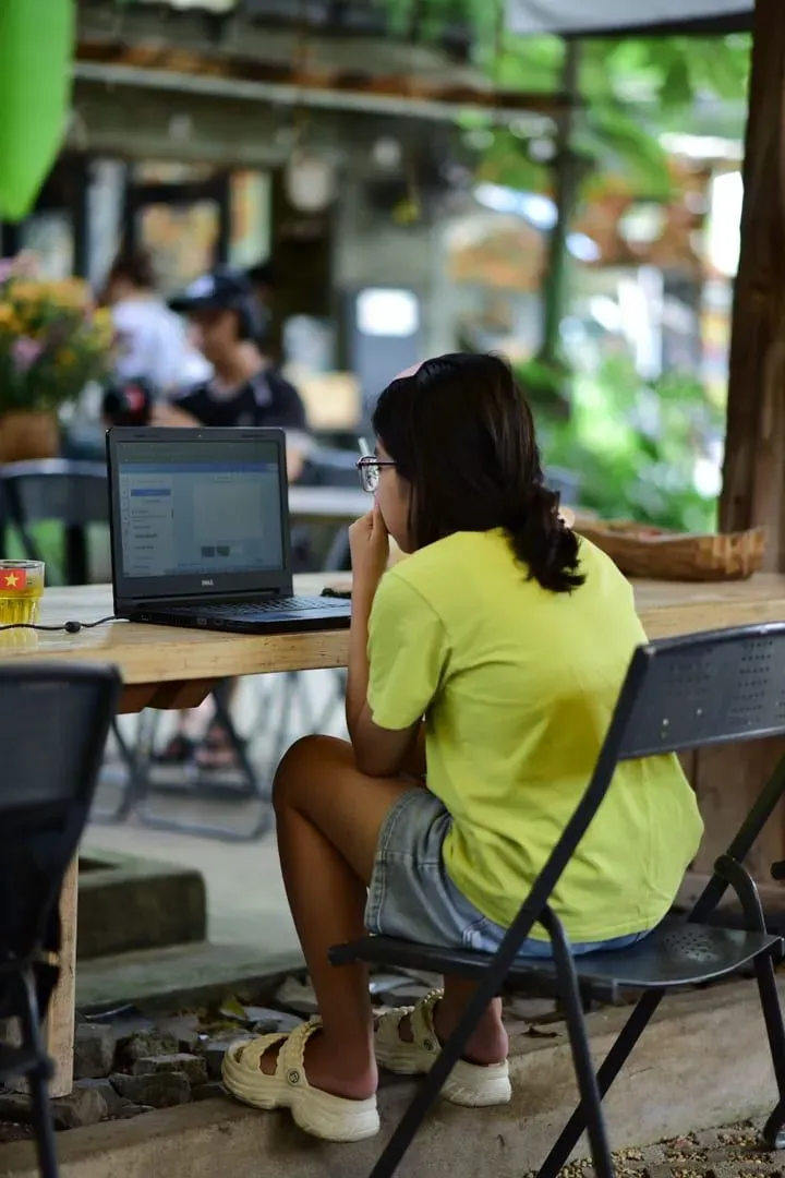 Focused remote worker on a laptop at an outdoor café, part of Koh Samui's nomad community