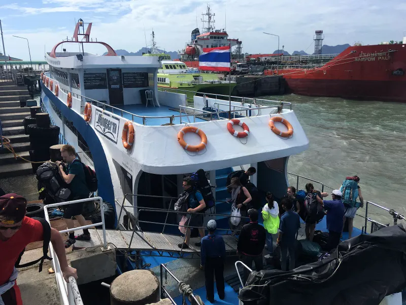 Backpacker con lo zaino che salgono su un traghetto passeggeri in un molo della terraferma sul Golfo di Thailandia