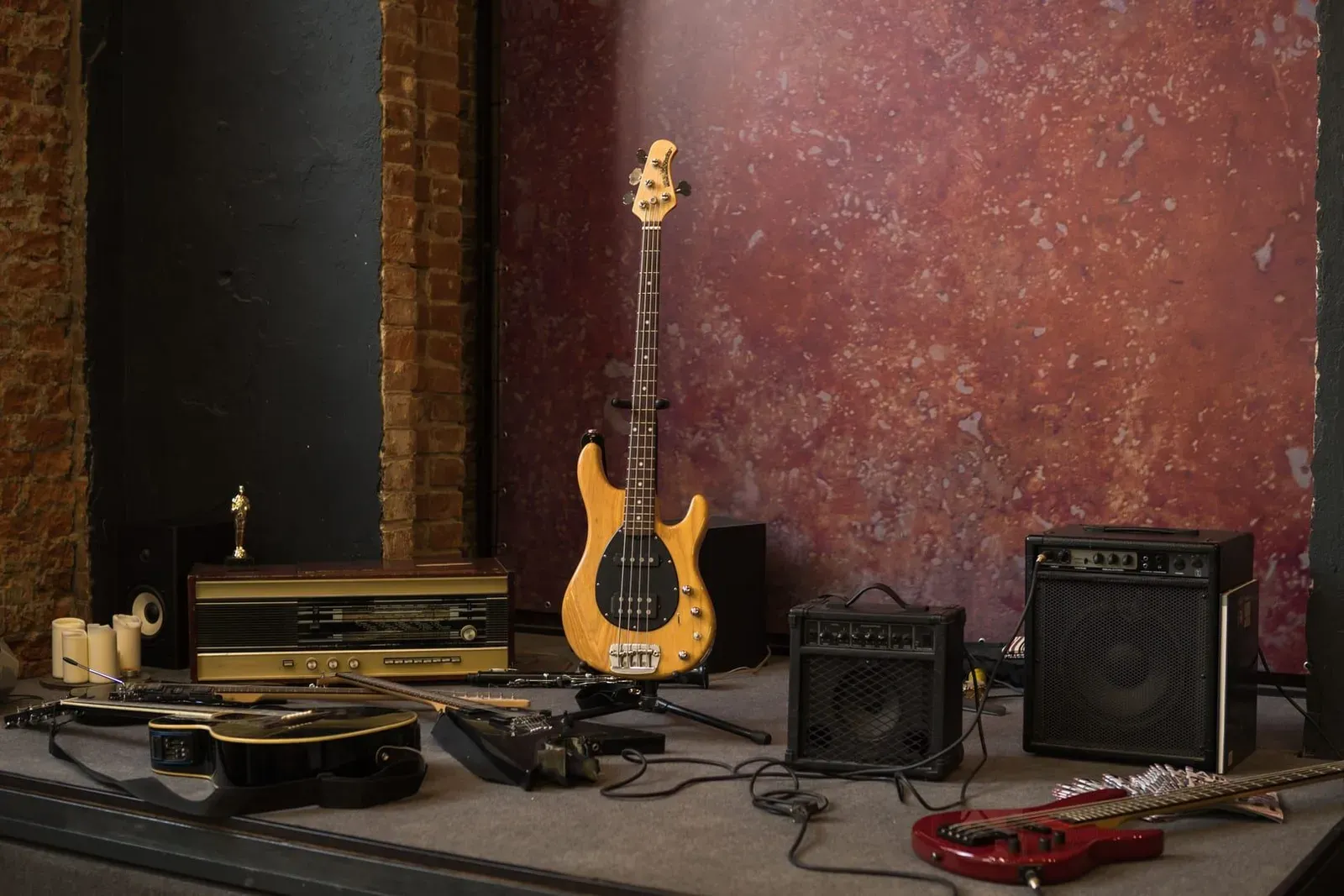 Electric and acoustic guitars on stands near loudspeakers, the kind of stock and PA gear an instrument shop carries