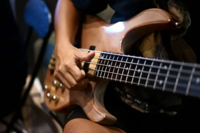 Close-up of a musician's hand playing an electric bass guitar