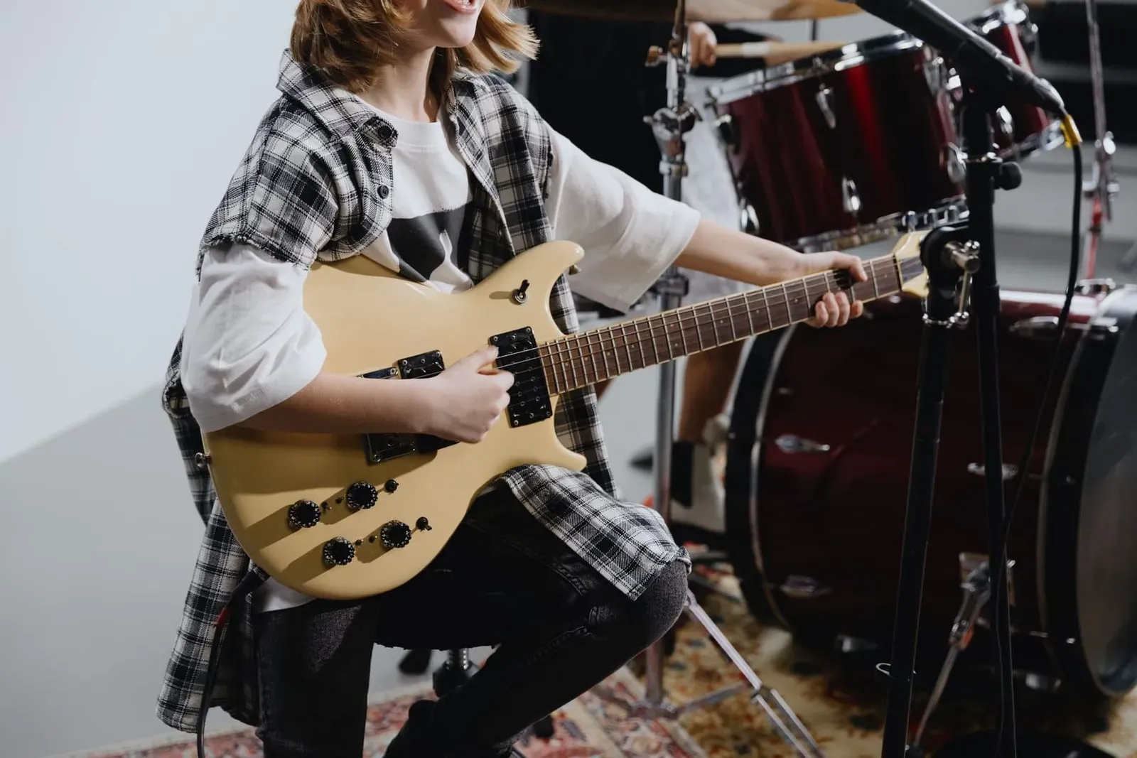 Young musician playing an electric guitar, the kind of school-age player who rehearses at a community music room