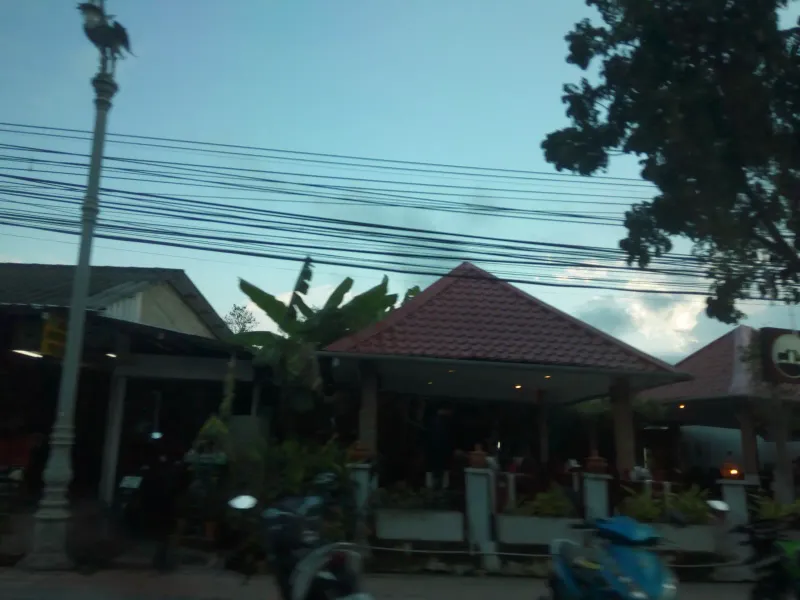 Red-roofed roadside restaurant at dusk in the Choeng Mon neighborhood, Koh Samui, near Kimpton Kitalay Samui