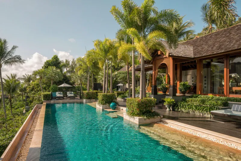Longue piscine de villa carrelée avec pavillon thaï et terrasses de palmiers sur la colline du Four Seasons Resort Koh Samui
