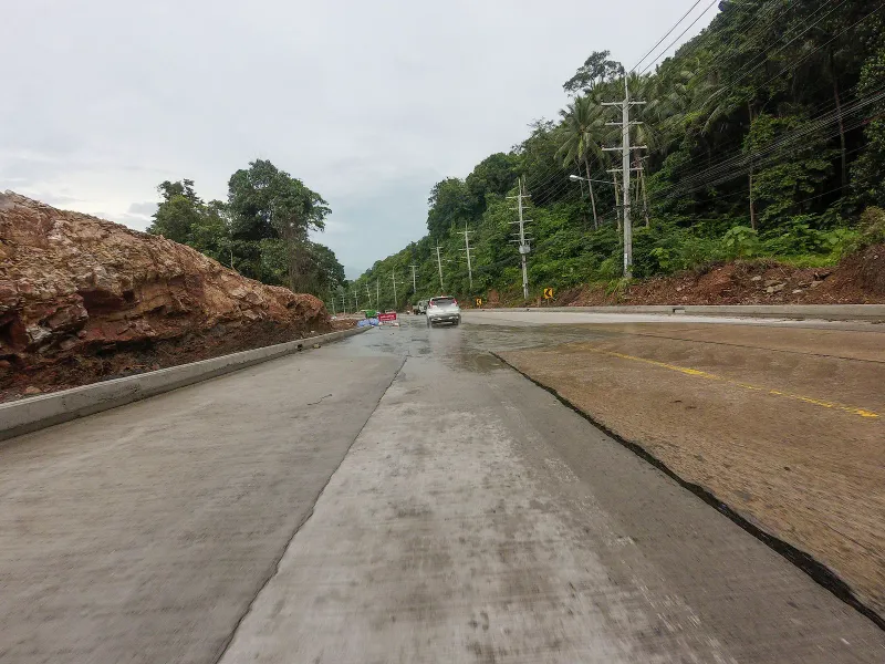 Coastal hillside road with coconut palms and power lines near Four Seasons Resort Koh Samui