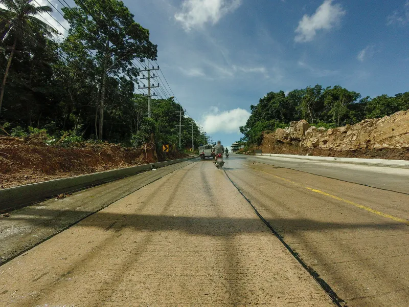 Jungle-lined hillside road climbing toward the Laem Yai headland on Koh Samui's northwest coast
