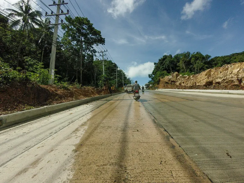 Winding jungle road with utility poles on the hillside route to Laem Yai Bay, Koh Samui