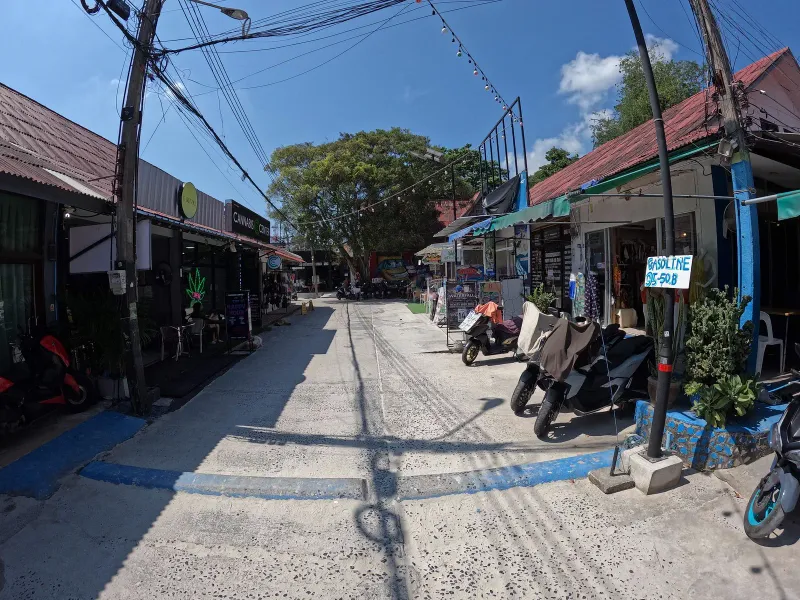 ハートリンのメインロードのレンタルショップの前に並ぶバイクと、頭上に張られたイルミネーション
