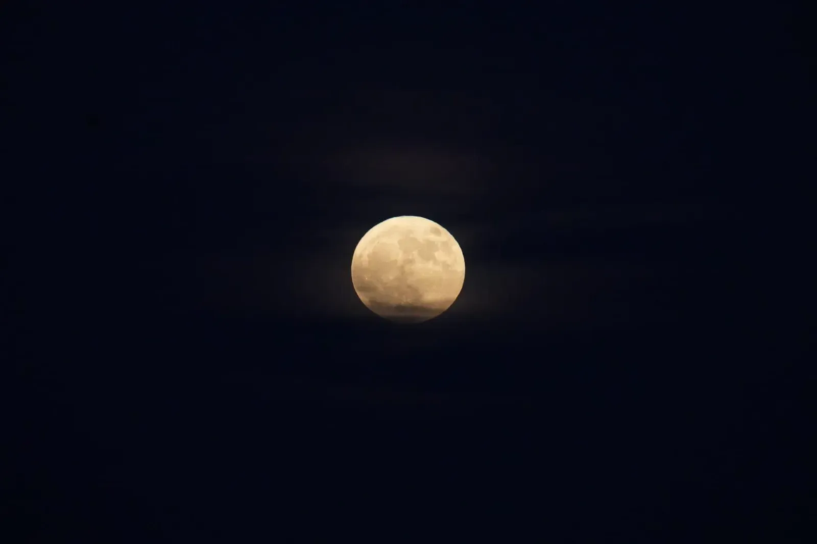 A bright full moon in a clear night sky, the lunar event that sets Koh Phangan's monthly Full Moon Party date