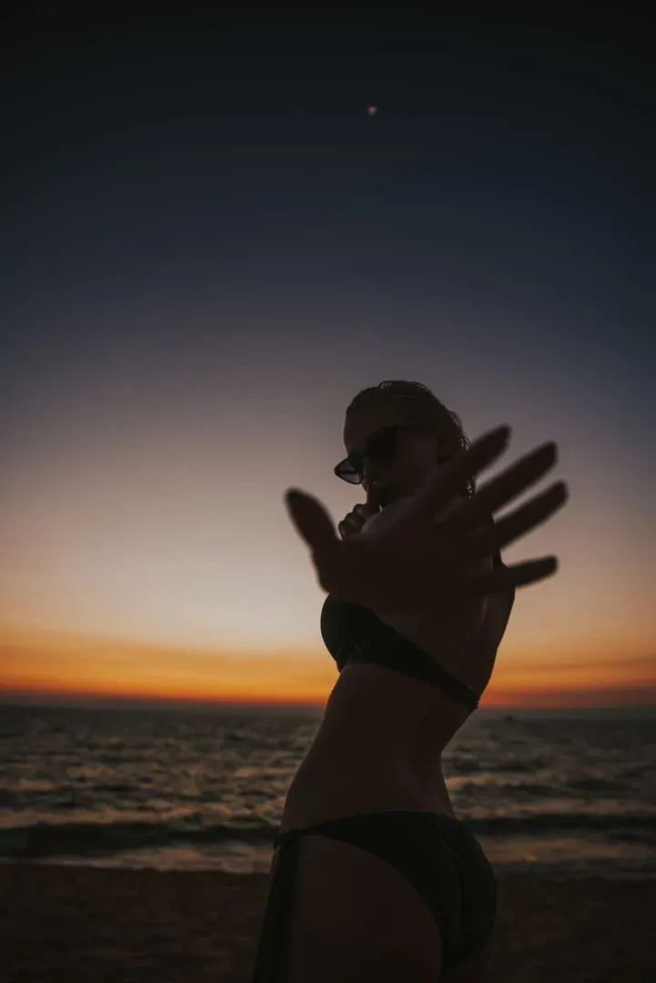 Traveler silhouette on the beach at sunset before the Koh Samui to Koh Phangan full moon party crossing