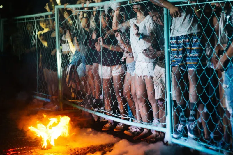 Crowd gathered around a bonfire at an outdoor night party, similar in spirit to Koh Phangan's monthly beach parties