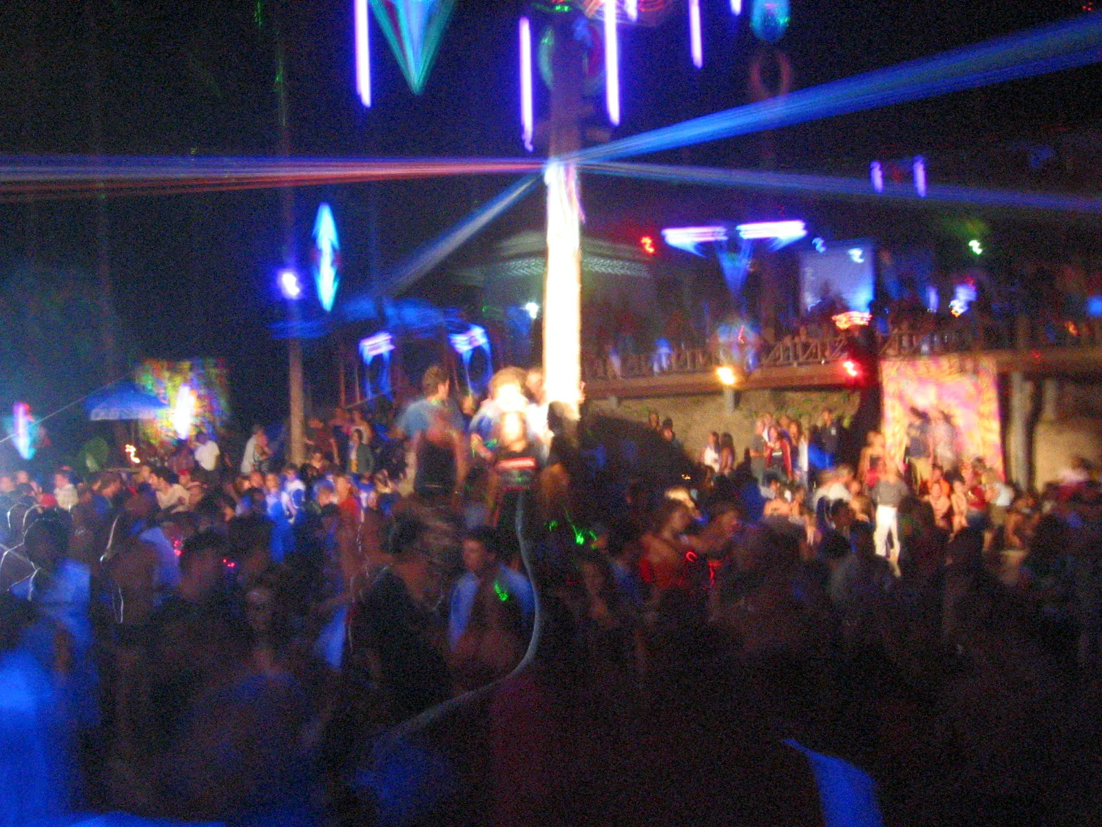 Crowd dancing under lasers at a Half Moon party on Koh Phangan