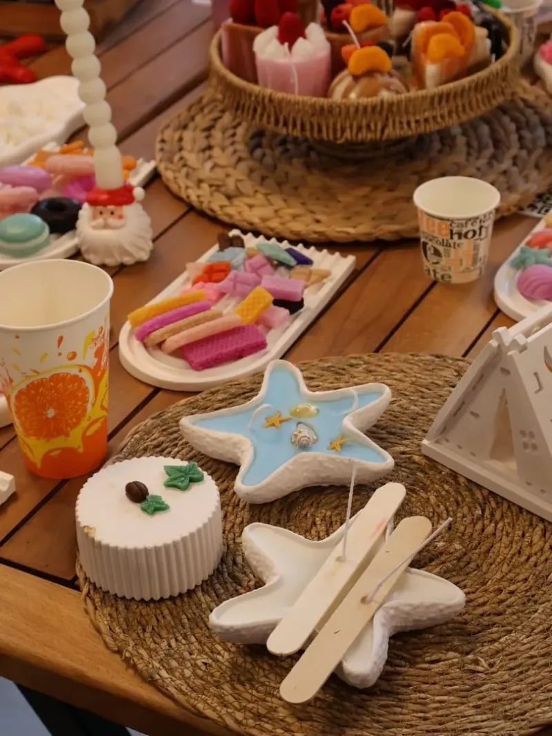 Handmade candles and soap bars arranged on a craft table