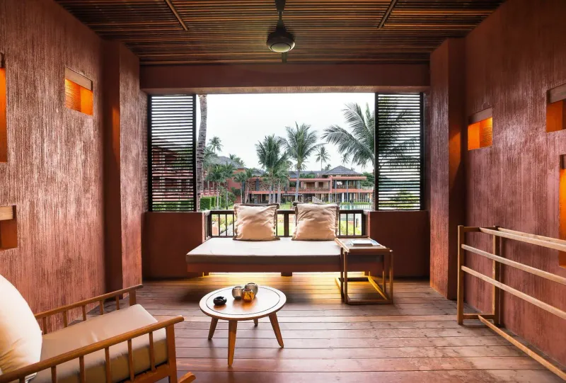 Letto da giorno sul balcone con vista sulle palme e sull'ala in terracotta dell'Hansar Samui