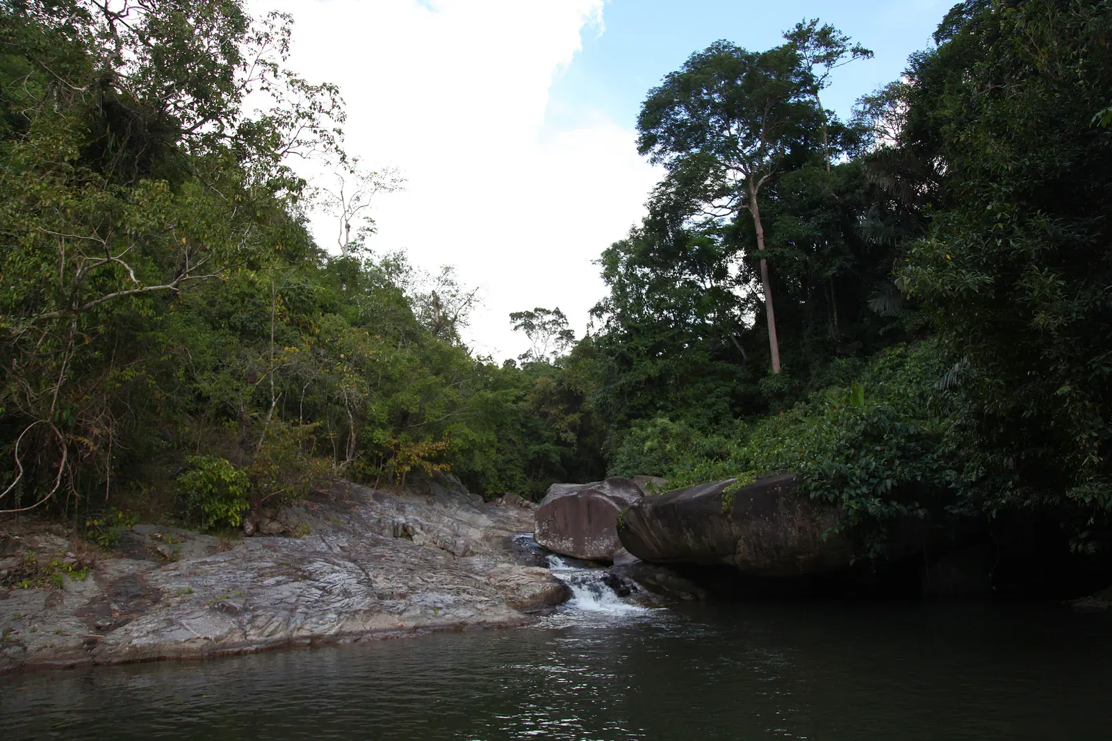 Die Hauptkaskade des Hin Lad Wasserfalls stürzt über Granitfelsen in einen Badepool
