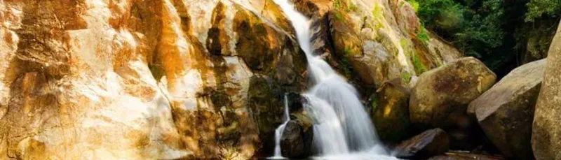 Weite Ansicht des Wassers, das über die Granitwand von Hin Lad fließt